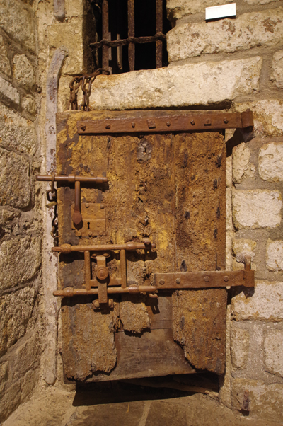 Vestige de l’époque carcérale au mont Saint-Michel, cette porte de cellule d’aspect fort peu engageant… (© Stéphane William Gondoin)